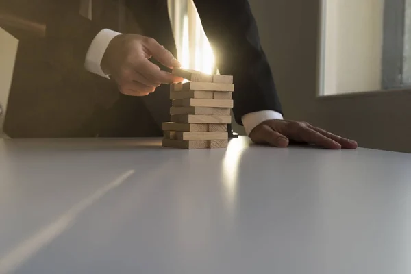 Uomo d'affari che costruisce una torre di blocchi di legno — Foto Stock