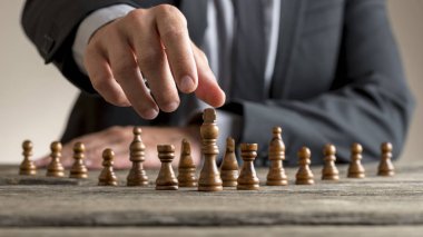 Karanlık Kral ulaşan takım elbise giyen işadamı satranç parça