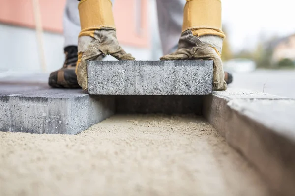 Bauarbeiter verlegt Pflasterplatten im Außenbereich — Stockfoto