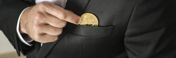 Geschäftsmann entfernt oder legt einen goldenen Bitcoin in die Tasche — Stockfoto