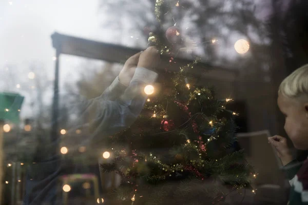 Young family decorating the Christmas tree