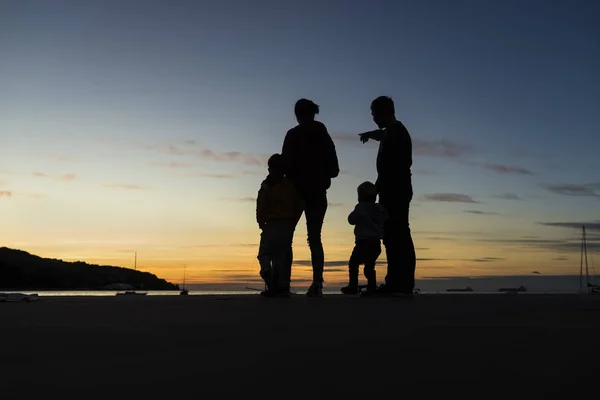 Silhouetted οικογένεια υπαίθρια κοιτάζοντας το ηλιοβασίλεμα — Φωτογραφία Αρχείου