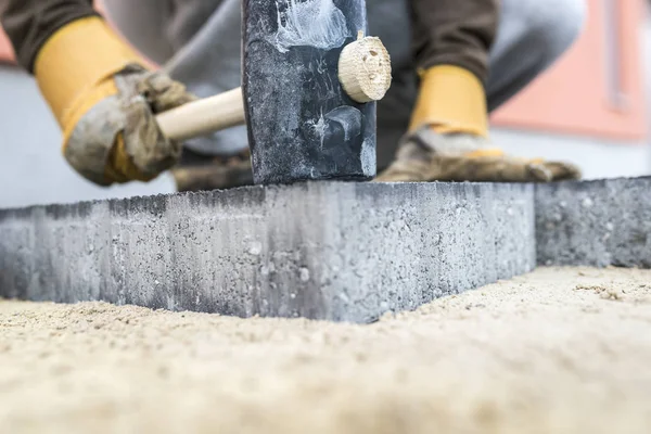 Construtor abaixando uma nova laje de pavimentação ou tijolo — Fotografia de Stock