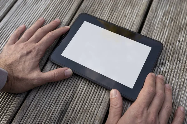 Mani di un uomo che tiene una tavoletta con display vuoto — Foto Stock