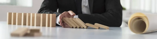 Breed panorama van een man die stoppen het domino-effect — Stockfoto