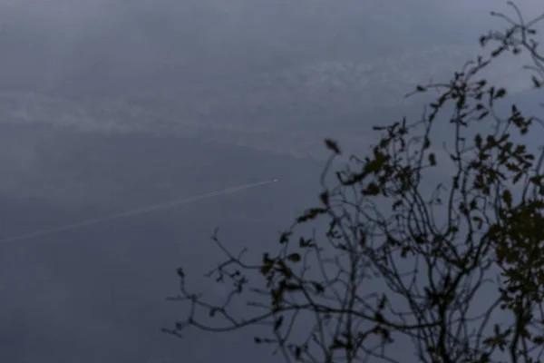 ジェット旅客機の飛行機雲の水の反射 — ストック写真