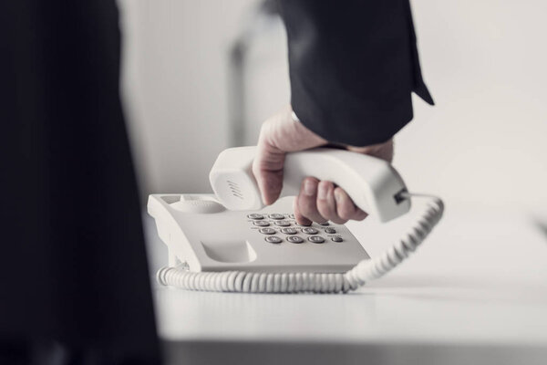 Ретро-тонированное изображение бизнесмена, набирающего телефонный номер
