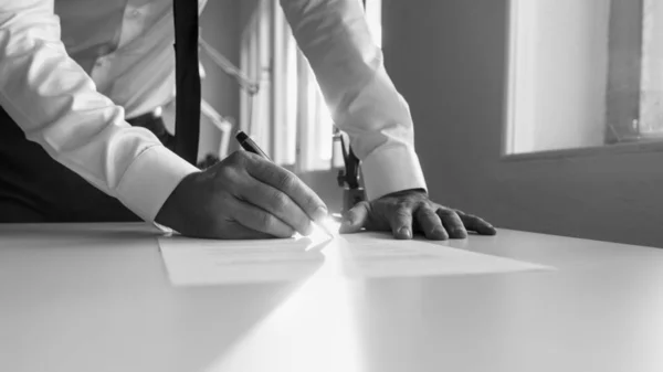 Imagen en escala de grises de un hombre firmando contrato o documento — Foto de Stock