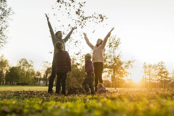 Keluarga muda bersukacita saat matahari terbit di musim gugur — Stok Foto