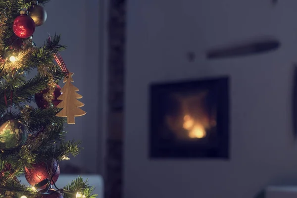 Decorated Christmas tree near a burning fire — Stock Photo, Image