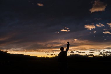 Yumruk yükselterek bir adam silüeti