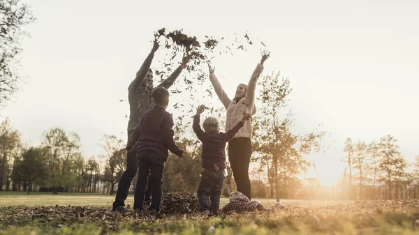 Effet rétro décoloré et tonique image d'une famille jouant avec autu — Photo