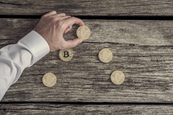İşadamı Beyaz gömlekli bir ol üzerinde altın bitcoins oynamaktan — Stok fotoğraf