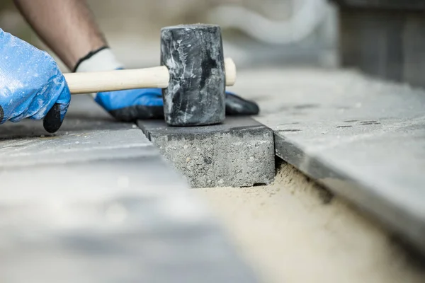 Construtor que estabelece uma pedra de pavimentação ou tijolo — Fotografia de Stock