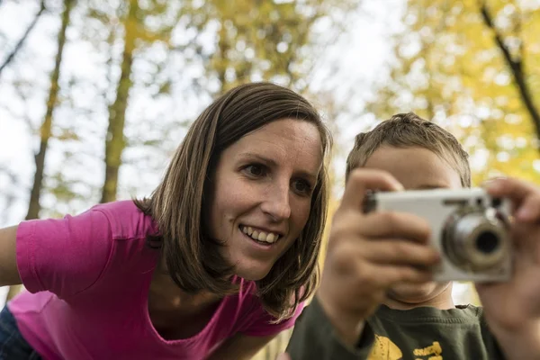 Jonge moeder kijken naar een afbeelding op een camera — Stockfoto