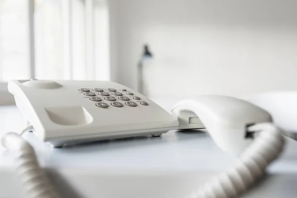 Klasszikus fehér vezetékes telefon készülék ki a horgot — Stock Fotó