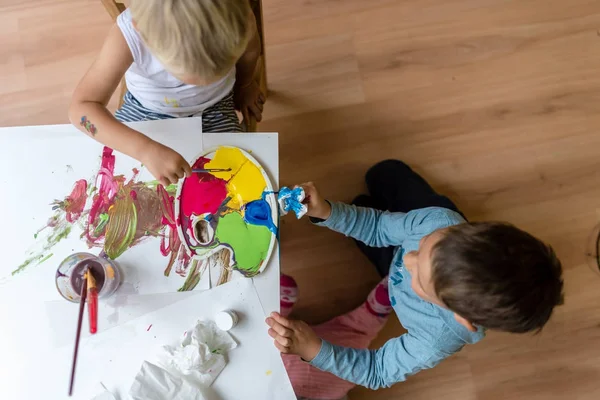 İki kardeş ile renkli boyalar boyama — Stok fotoğraf