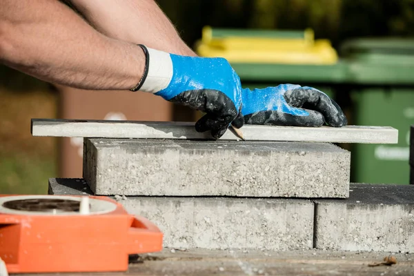 Bauarbeiter markieren einen Pflasterstein oder Block, um ihn zu schneiden — Stockfoto