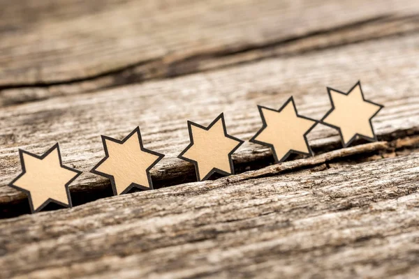 Five stars on a rustic wooden boards — Stock Photo, Image
