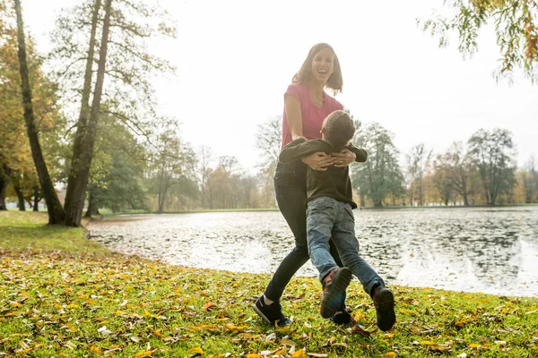 Ibu yang bahagia bermain dengan anaknya di musim gugur — Stok Foto
