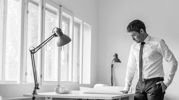 Empresário de camisa branca em pé em seu escritório, apoiando-se no — Fotografia de Stock