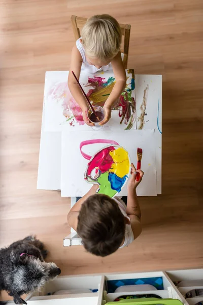 İki çocuk ile renkli boyalar nefes nefese — Stok fotoğraf