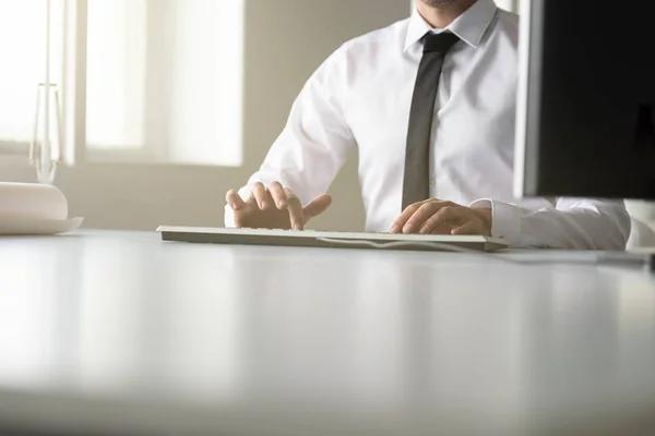 Empresário sentado digitando em um teclado com fio — Fotografia de Stock