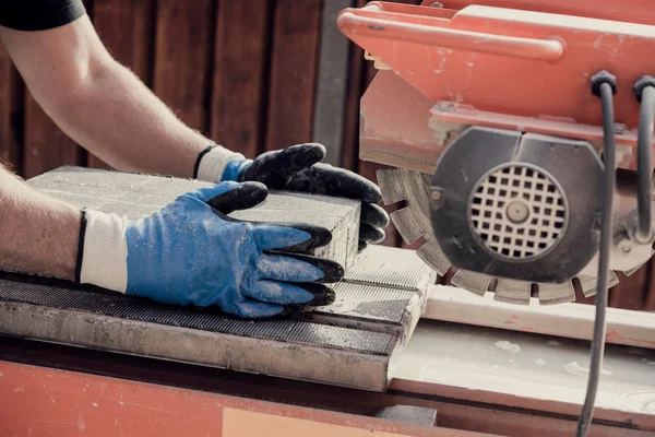 Trabajador preparando bloque de hormigón para cortarlo con una amoladora angular — Foto de Stock