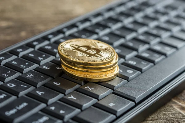 Svart tangentbord med högen av gyllene Bitcoins — Stockfoto