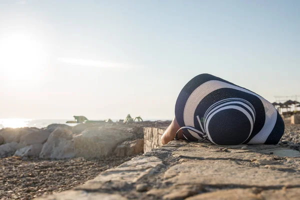 Žena leží na skalnatém promenáda — Stock fotografie