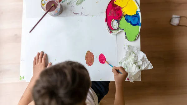 Genç çocuk kağıda renkli boyalar ile boyama — Stok fotoğraf