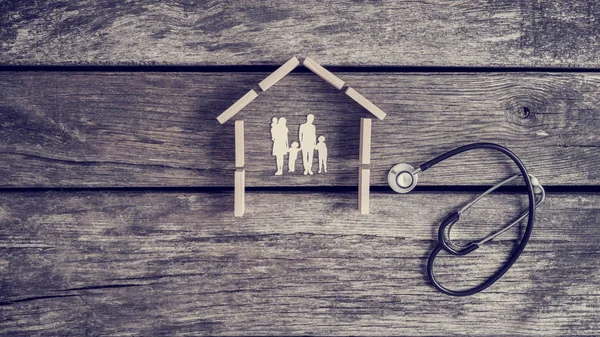 Cut outs van een gezin met kinderen in een huis met een stethoscoop — Stockfoto
