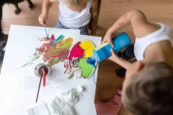 Bambini che mescolano vernici colorate mentre dipingono — Foto Stock