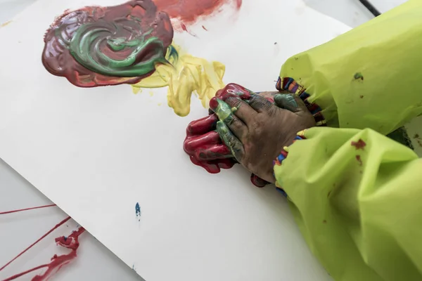 Criança brincando com tintas fazendo pintura à mão — Fotografia de Stock