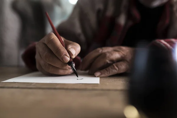 Un uomo con le mani sporche che scrive su un foglio di carta — Foto Stock