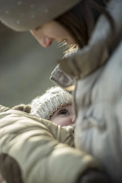 Mujer amamantando a un niño pequeño usando ropa de invierno — Foto de Stock