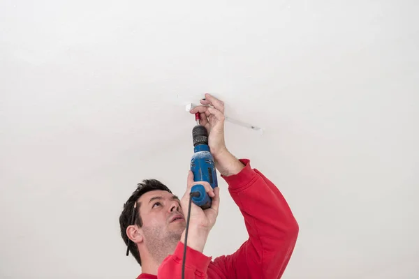 Builder using a small handheld electric drill Stock Photo