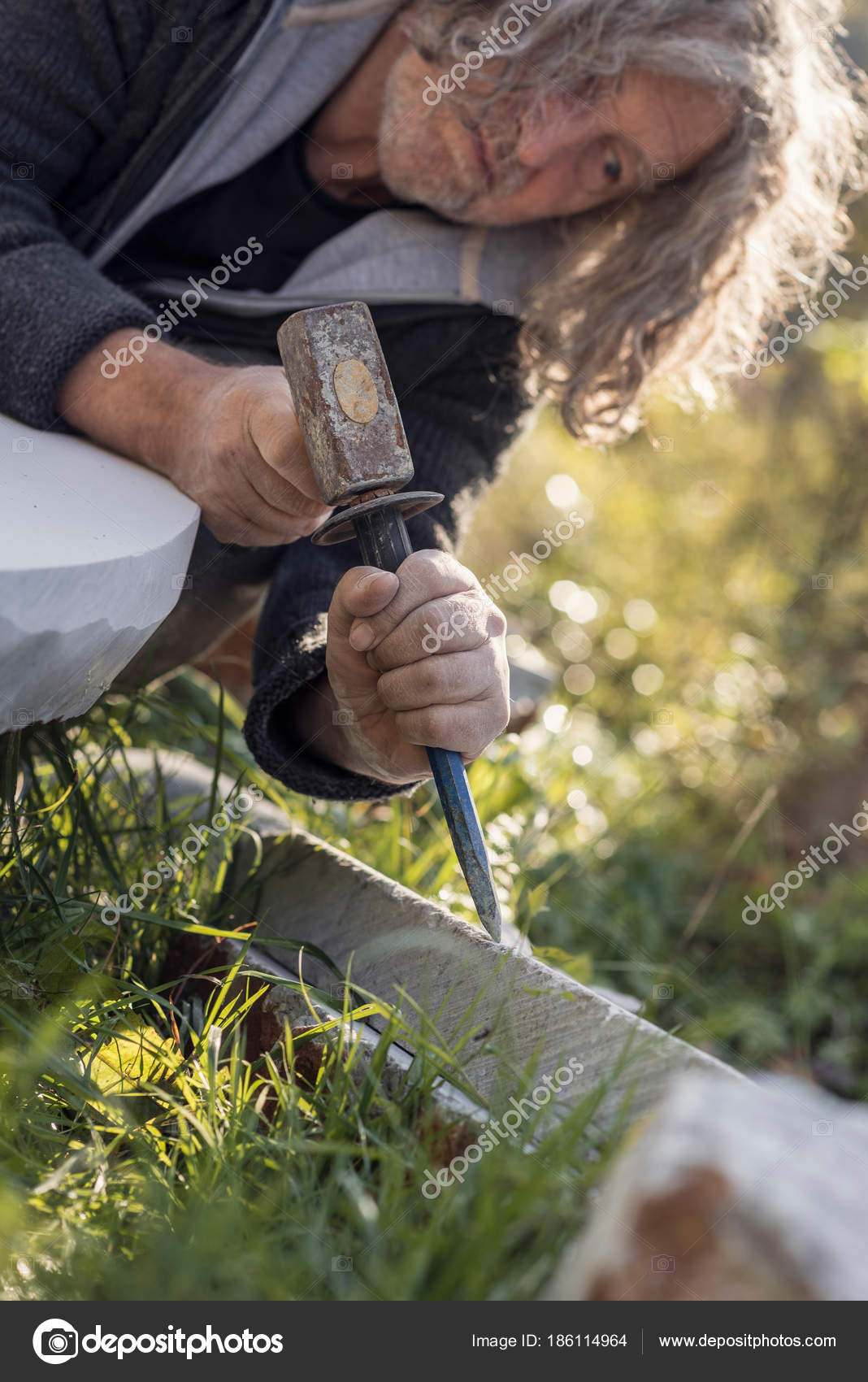 Sculptor sculpting with chisel and hammer in marble — Stock Photo
