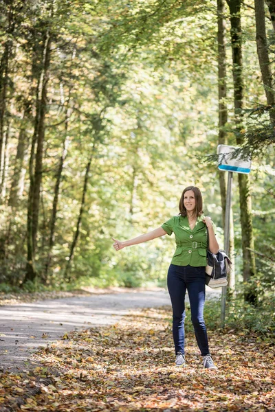 Femme auto-stoppeur debout sur le bord de la route en automne avant — Photo