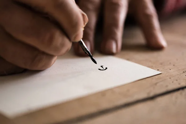 Pessoa que usa uma caneta e tinta para fazer caligrafia — Fotografia de Stock