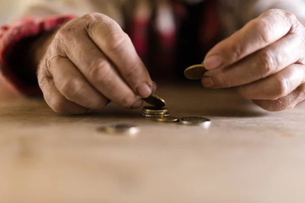 Számlálás érmék az íróasztalánál ül, piszkos kéz férfi — Stock Fotó