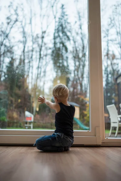 Маленький мальчик преклонил колени на деревянном полу — стоковое фото