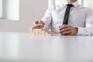 Tanımlanamayan işadamı birden çok küçük ahşap bloklar istifleme