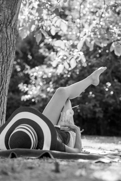 Imagen monocromática de una mujer que se relaja en el jardín tumbada en un ru — Foto de Stock