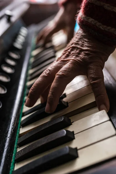 Oude muzikant speelt een piano binnenshuis in een close-up weergave van zijn ha — Stockfoto