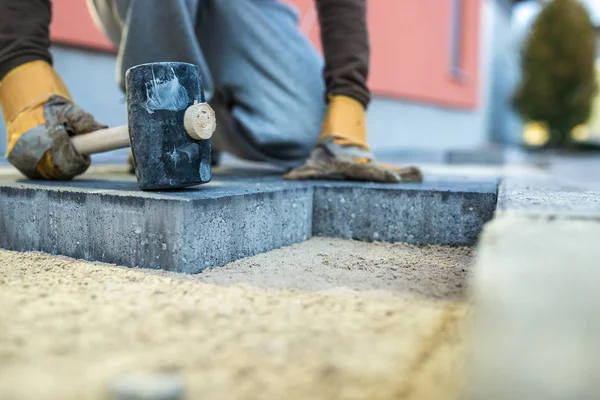 Workman tamping down a new paving brick — Stock Photo, Image