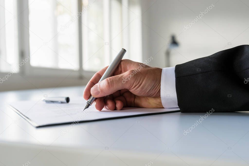 Low view of businessman hand signing business contract