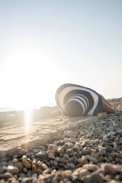 Sütkérezve a meleg nyári napon egy köves strandon napozással nő — Stock Fotó