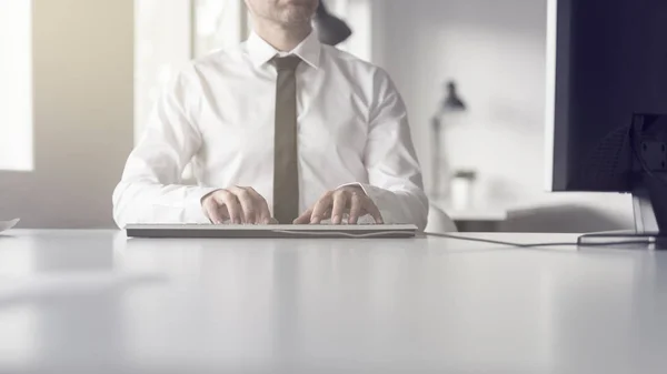 Geschäftsmann sitzt in seinem Büro und tippt — Stockfoto