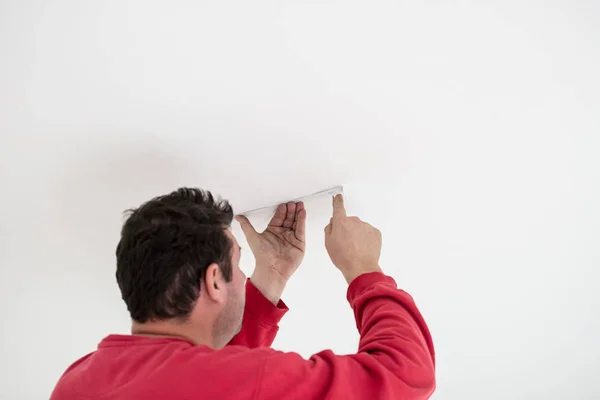 Builder attaching a cable or conduit to a ceiling — Stock Photo, Image